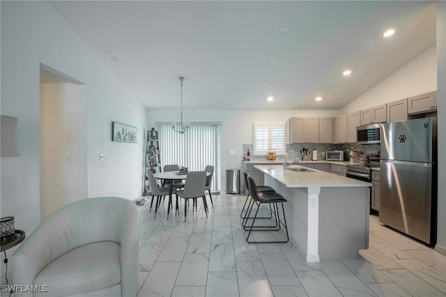 kitchen with gray cabinetry, light countertops, appliances with stainless steel finishes, marble finish floor, and a sink