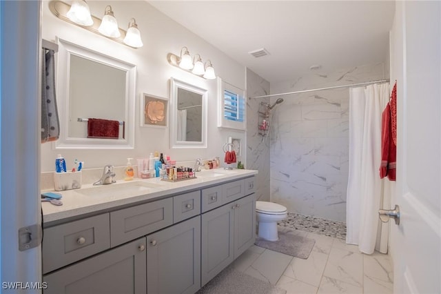 bathroom featuring visible vents, toilet, marble finish floor, a sink, and double vanity