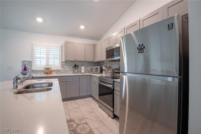 kitchen with marble finish floor, gray cabinets, a sink, tasteful backsplash, and stainless steel appliances