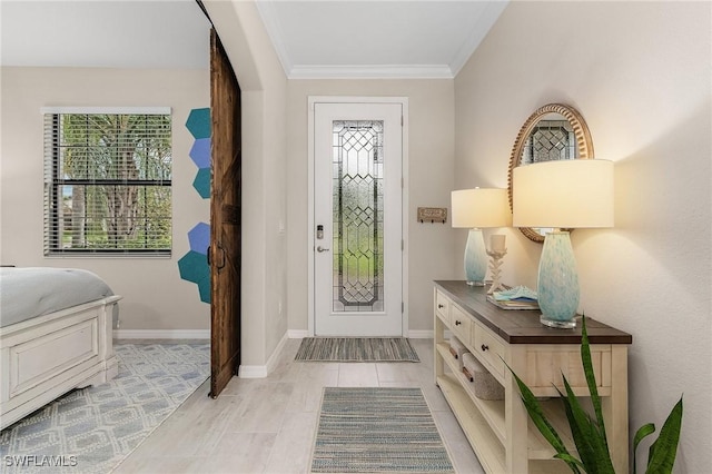 entryway with light wood-style flooring, baseboards, and ornamental molding