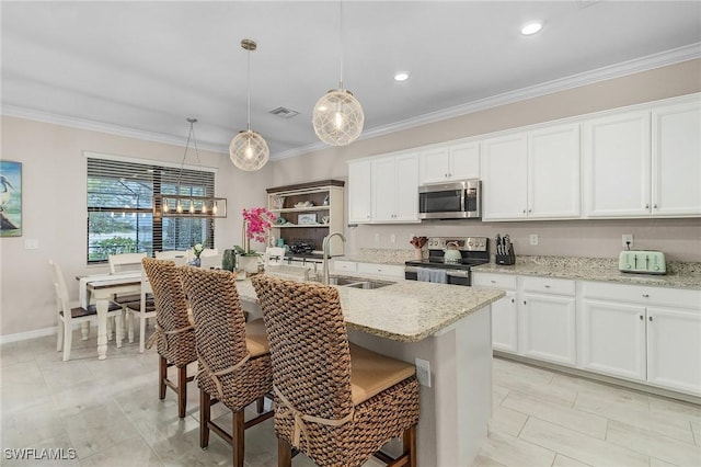 kitchen with white cabinets, stainless steel appliances, crown molding, and a sink