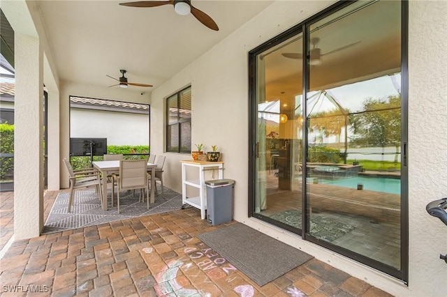 view of patio with outdoor dining area, a ceiling fan, and a pool with connected hot tub