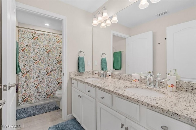 bathroom with double vanity, toilet, visible vents, and a sink