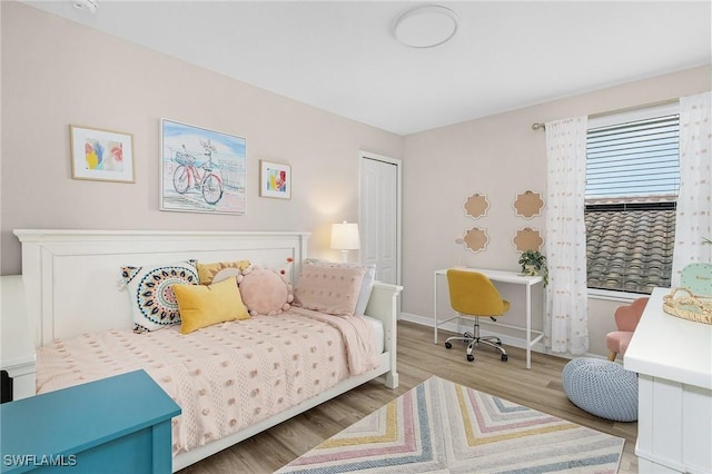 bedroom featuring baseboards and wood finished floors