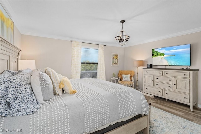 bedroom with an inviting chandelier, wood finished floors, and crown molding