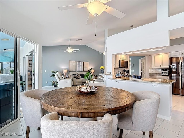 dining area with light tile patterned floors, visible vents, ceiling fan, and vaulted ceiling