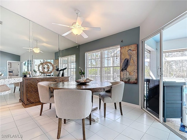 dining space with lofted ceiling, light tile patterned flooring, and a ceiling fan