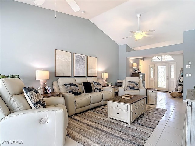 living area featuring light tile patterned floors, a ceiling fan, and high vaulted ceiling