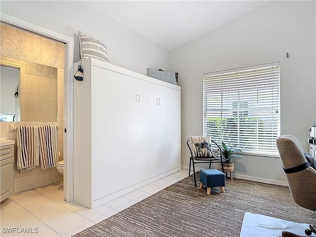 sitting room featuring light tile patterned flooring and vaulted ceiling