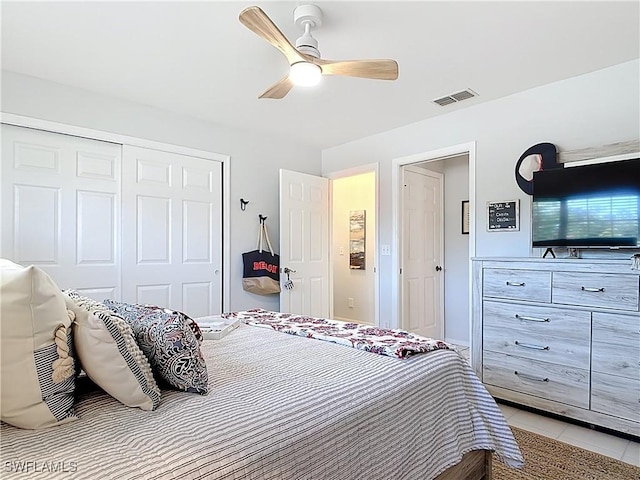 bedroom featuring light tile patterned floors, a ceiling fan, visible vents, and a closet