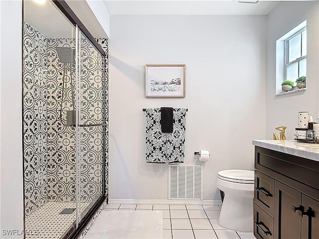 bathroom featuring vanity, toilet, visible vents, and a tile shower