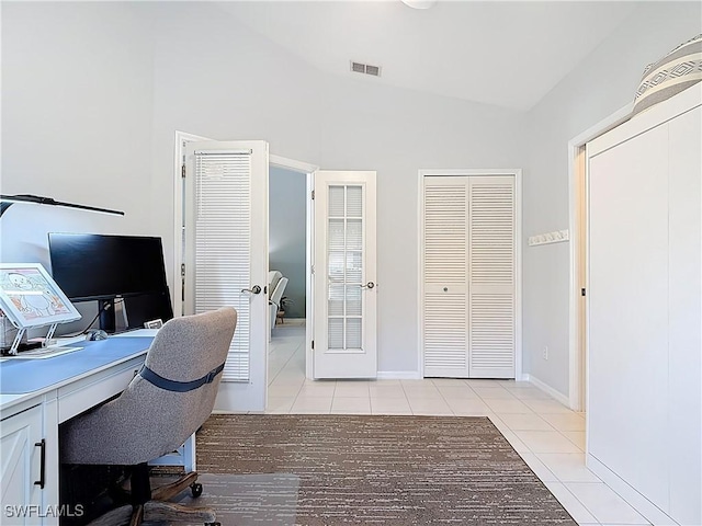 office featuring light tile patterned floors, visible vents, baseboards, and vaulted ceiling