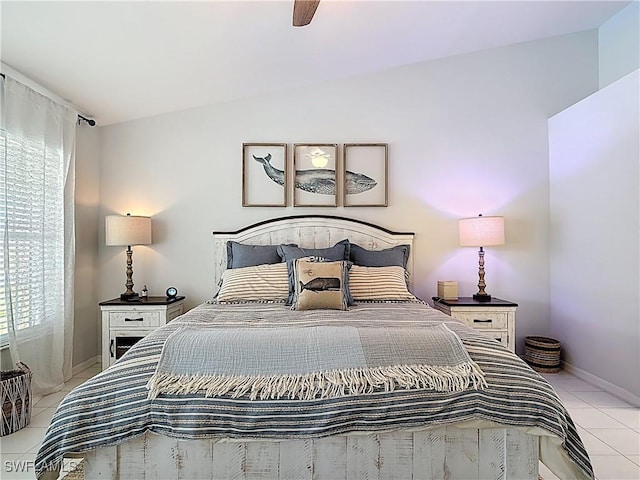 bedroom featuring ceiling fan, baseboards, lofted ceiling, and light tile patterned flooring