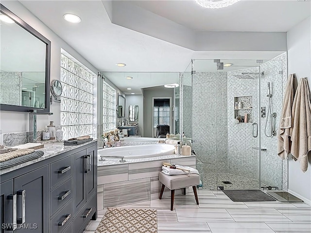 bathroom with vanity, a garden tub, and a shower stall