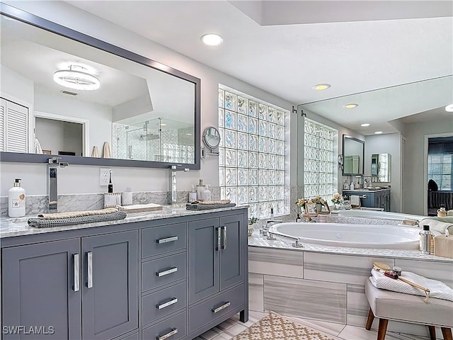 full bathroom with recessed lighting, a bath, vanity, and tile patterned flooring