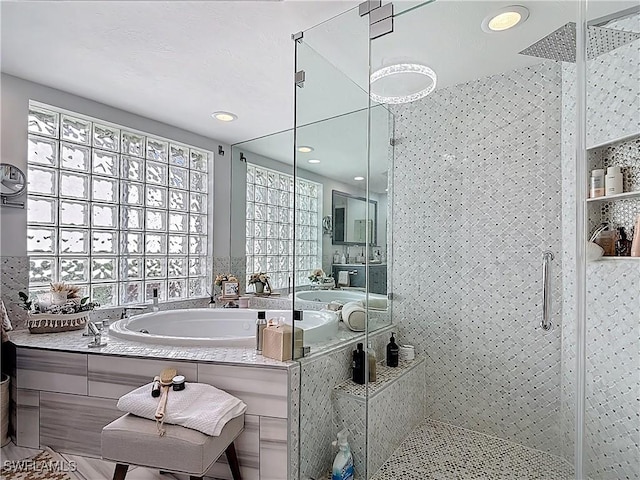 full bathroom featuring a bath and a shower stall