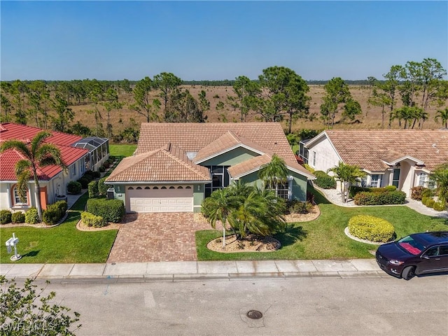 view of front facade with a tile roof, a front yard, stucco siding, driveway, and an attached garage