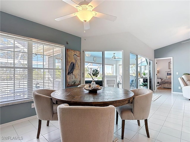 dining room featuring vaulted ceiling, light tile patterned flooring, a ceiling fan, and baseboards