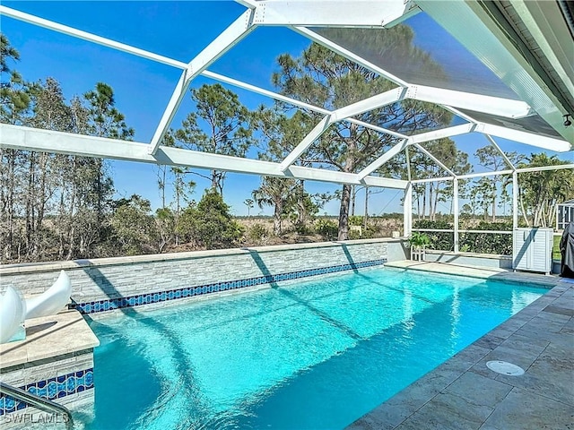 pool featuring glass enclosure and a patio