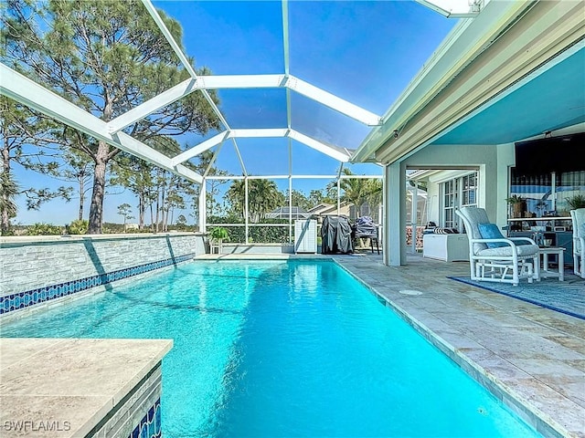 outdoor pool with glass enclosure and a patio area