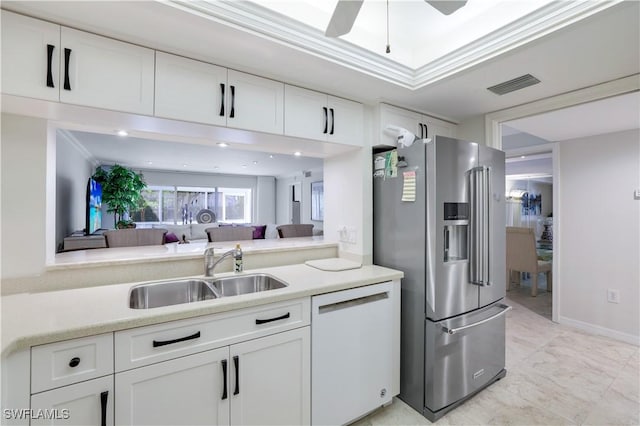 kitchen featuring visible vents, high end refrigerator, white dishwasher, white cabinets, and a sink