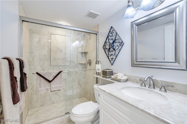 bathroom featuring visible vents, a shower stall, toilet, and vanity