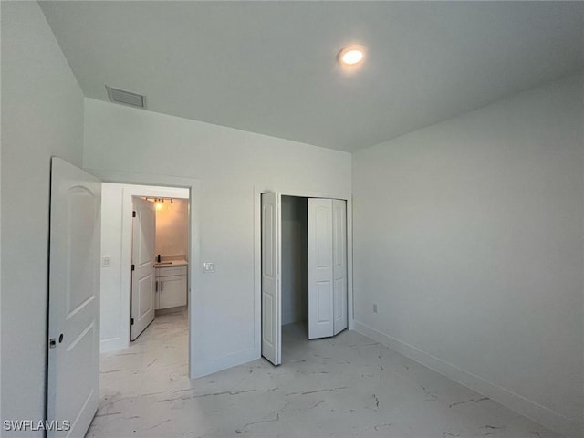 unfurnished bedroom with visible vents, marble finish floor, a closet, and baseboards