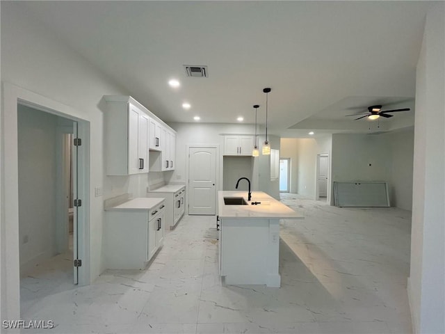 kitchen featuring visible vents, an island with sink, recessed lighting, a sink, and marble finish floor