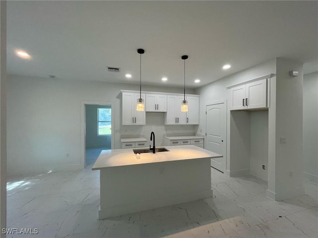 kitchen featuring baseboards, recessed lighting, marble finish floor, and a sink