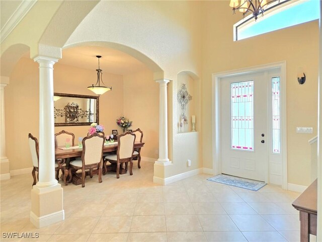 11573 SW Dallas Dr N, Lake Suzy, FL 34269 - foyer with light tile patterned floors, baseboards, arched walkways, decorative columns, and a high ceiling