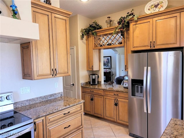 11573 SW Dallas Dr N, Lake Suzy, FL 34269 - kitchen with light stone counters, light tile patterned floors, appliances with stainless steel finishes, under cabinet range hood, and brown cabinetry