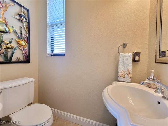 11573 SW Dallas Dr N, Lake Suzy, FL 34269 - bathroom with toilet, a sink, tile patterned floors, and baseboards