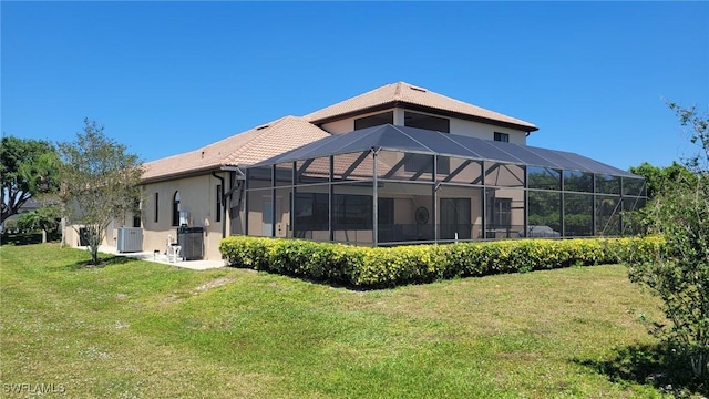 11573 SW Dallas Dr N, Lake Suzy, FL 34269 - rear view of property featuring a tiled roof, a lanai, stucco siding, a yard, and central AC