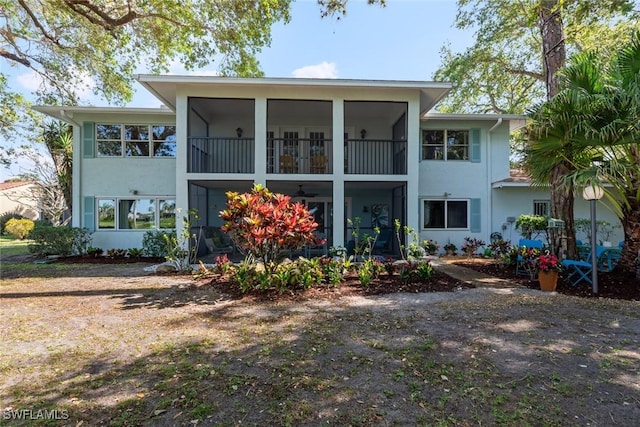 back of property with stucco siding and a sunroom