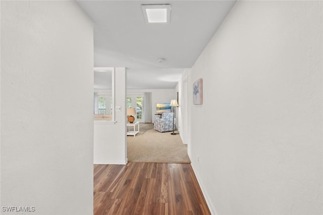 hallway featuring baseboards and wood finished floors