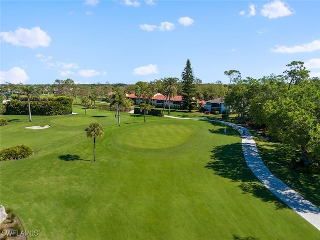 surrounding community with a lawn and view of golf course