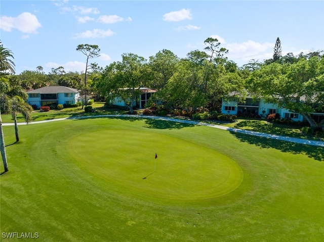 view of community with view of golf course and a lawn