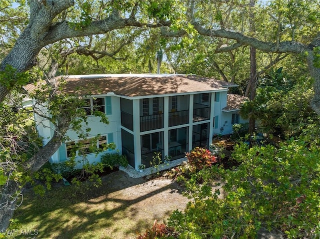 back of house featuring stucco siding and a sunroom