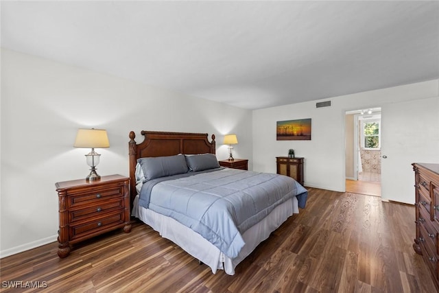 bedroom featuring dark wood finished floors, baseboards, and visible vents