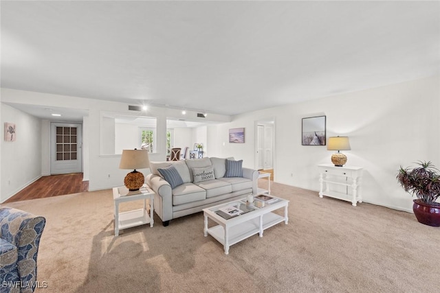 living room with visible vents, carpet floors, and rail lighting