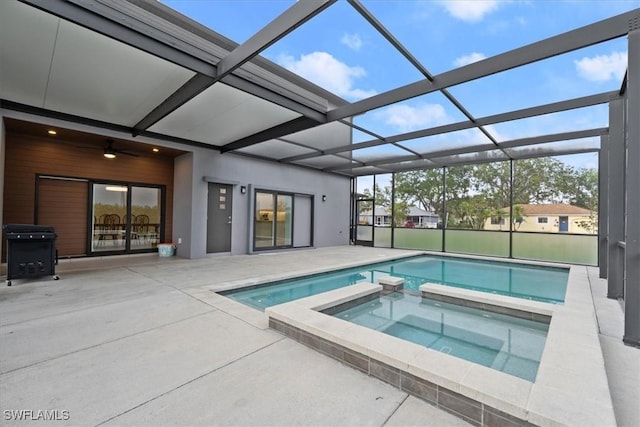 view of swimming pool with glass enclosure, a pool with connected hot tub, and a patio