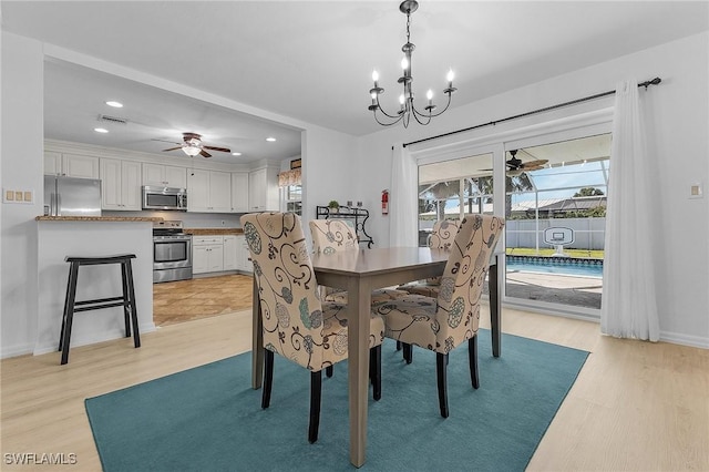 dining space with recessed lighting, ceiling fan with notable chandelier, baseboards, and light wood finished floors