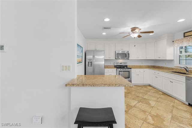 kitchen with visible vents, ceiling fan, a sink, white cabinets, and appliances with stainless steel finishes