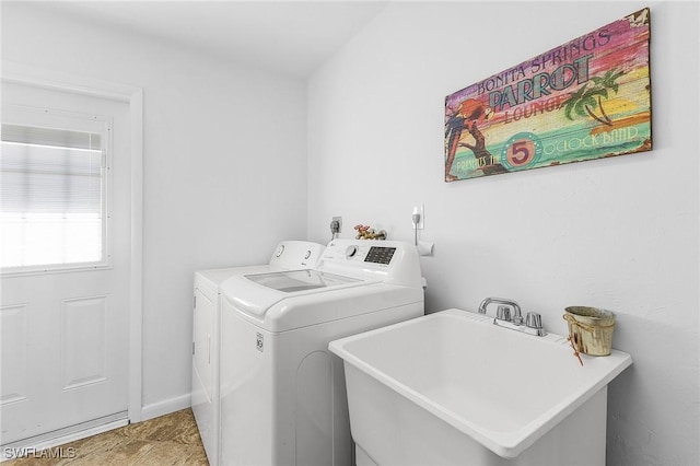 washroom featuring a sink, laundry area, and washer and clothes dryer