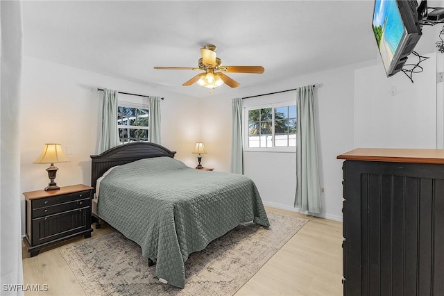 bedroom with baseboards, light wood-type flooring, and ceiling fan