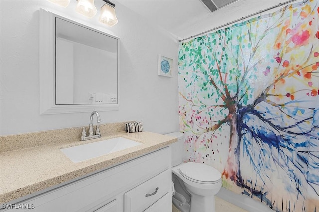 bathroom with curtained shower, vanity, and toilet