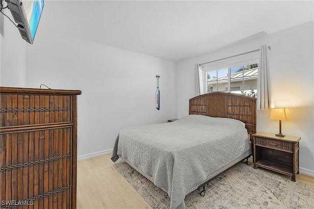 bedroom with light wood-style flooring and baseboards