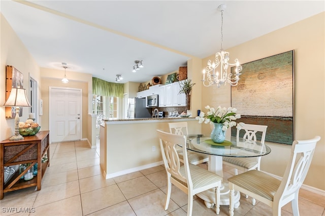 dining space featuring light tile patterned floors, baseboards, and an inviting chandelier