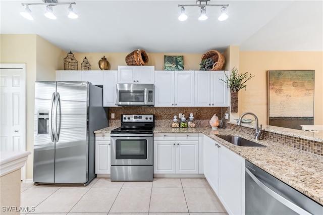 kitchen featuring light tile patterned floors, stainless steel appliances, tasteful backsplash, and a sink