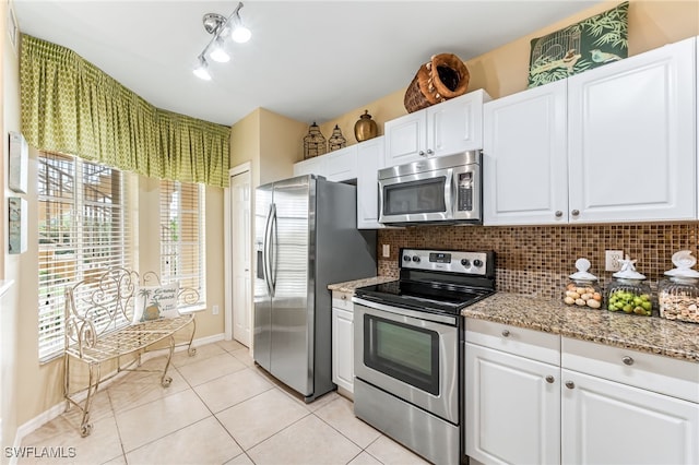 kitchen featuring decorative backsplash, appliances with stainless steel finishes, light tile patterned flooring, and white cabinetry